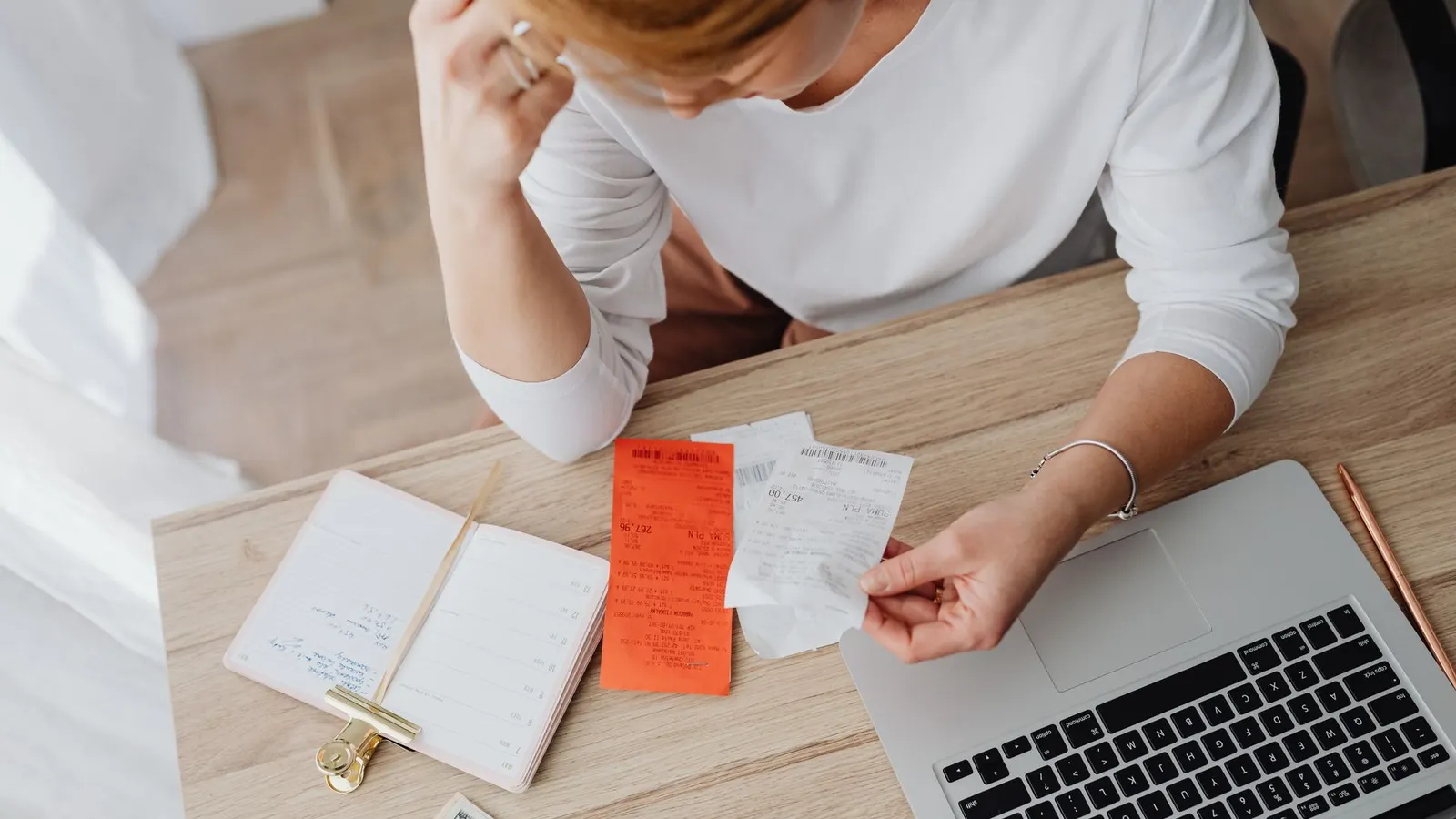 Comparing paper receipts beside a laptop at a desk