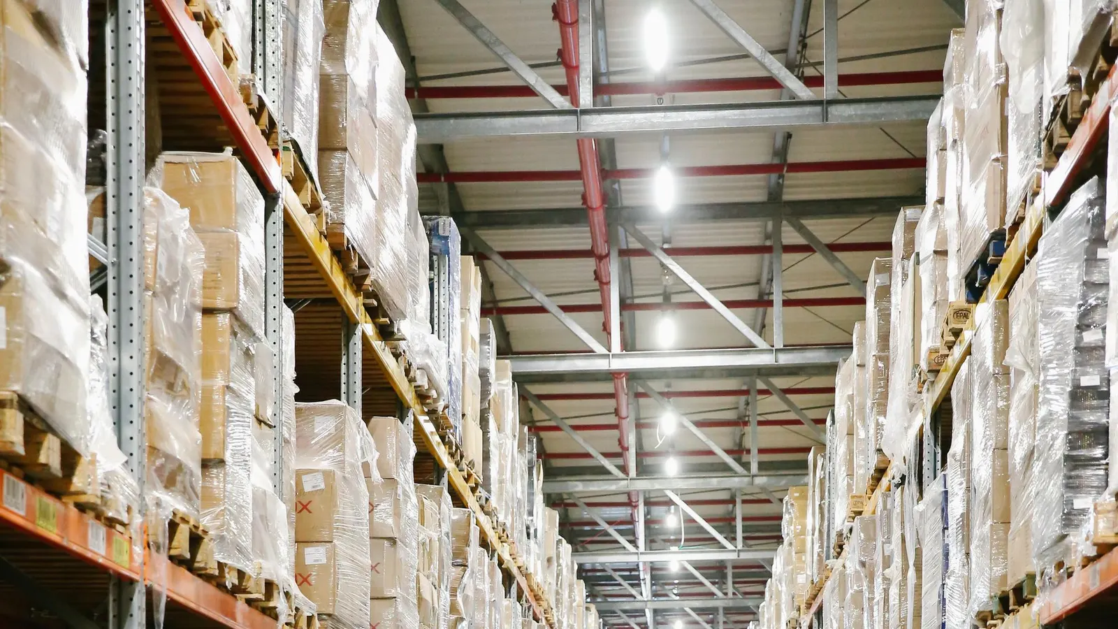 Shrink-wrapped pallets on high racking in a warehouse aisle