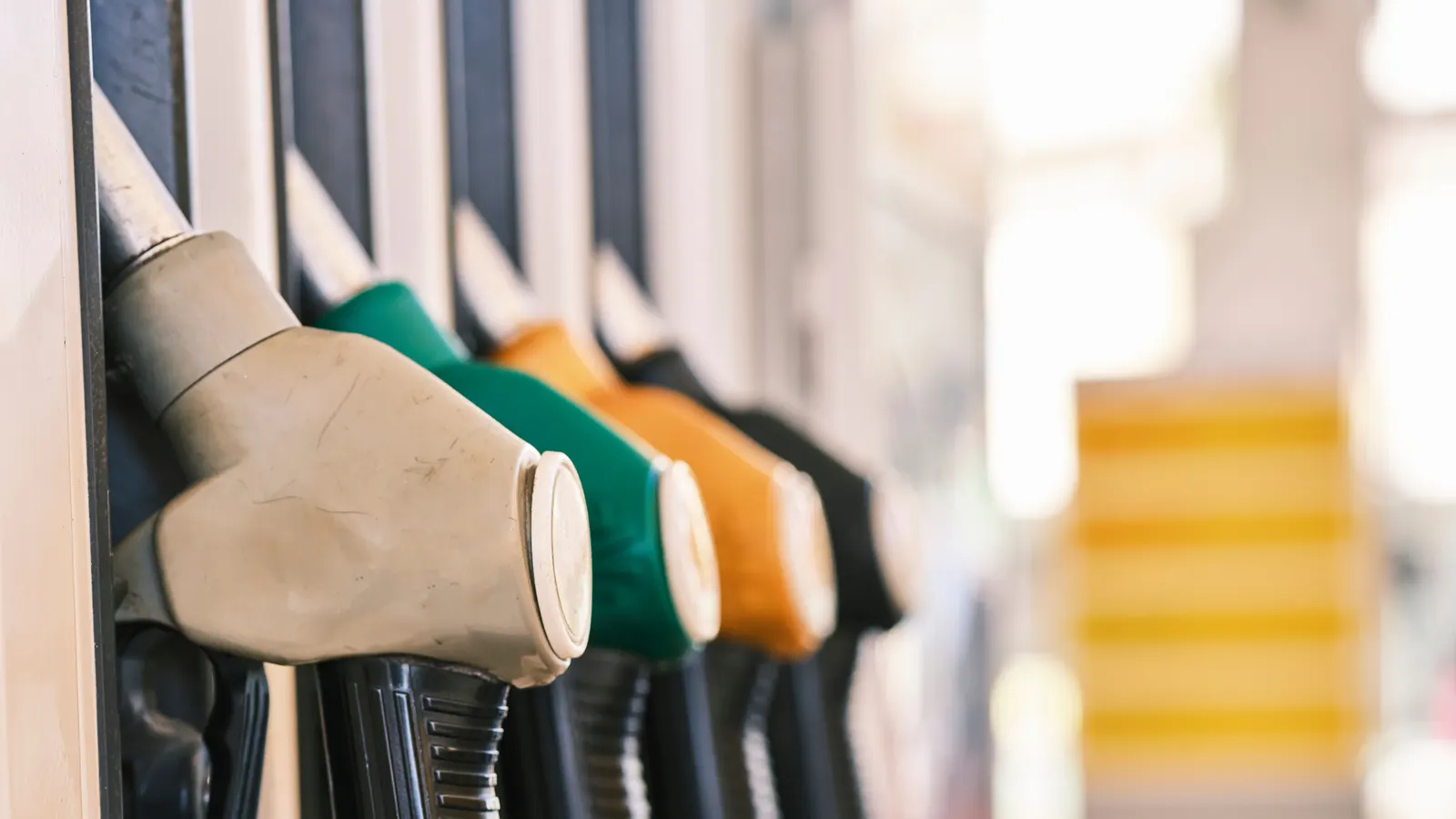 A row of fuel pump nozzles in their holsters at a filling station, seen close up