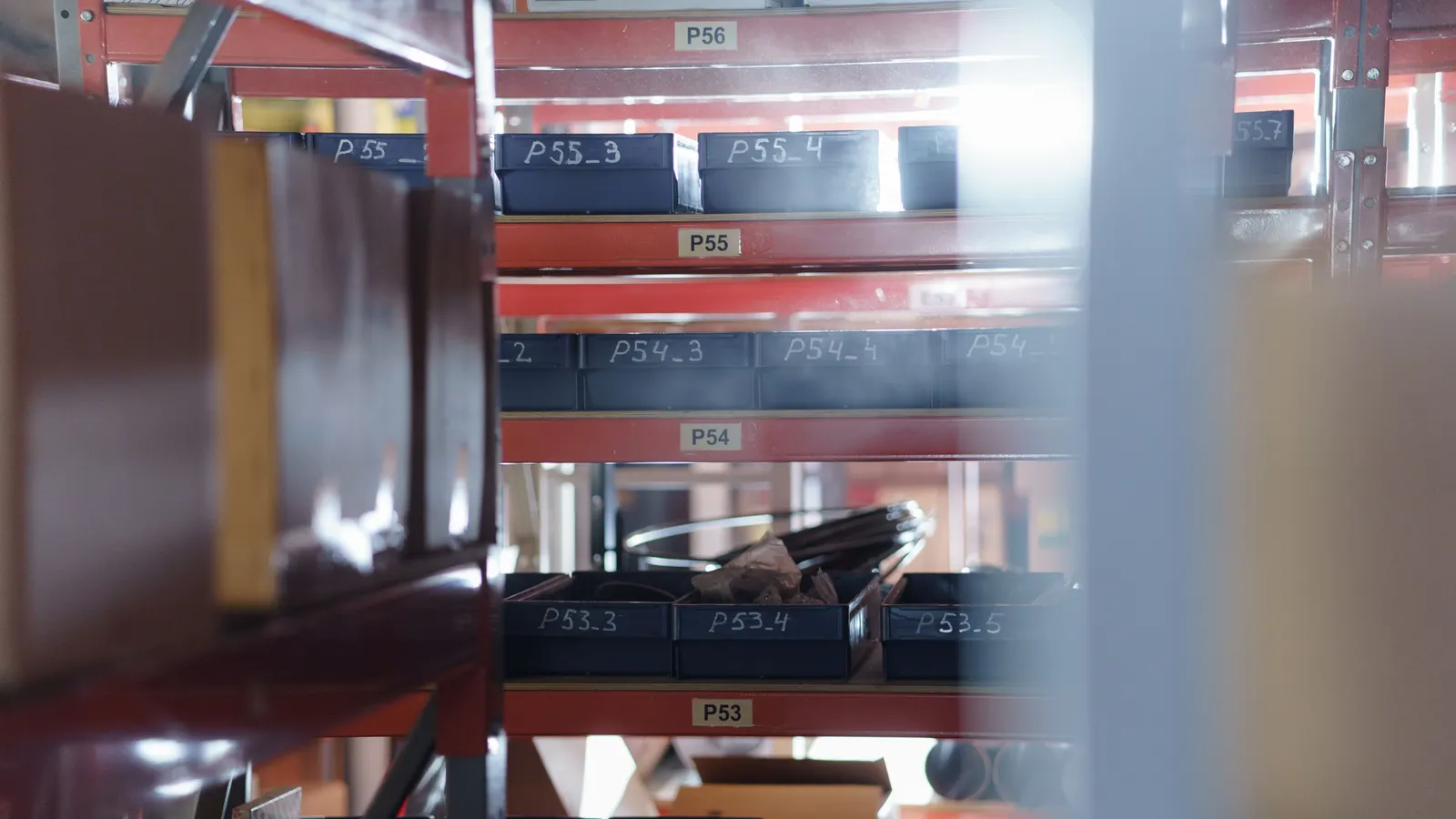 Warehouse shelving with rows of numbered storage bins, each labelled like a page in a ledger